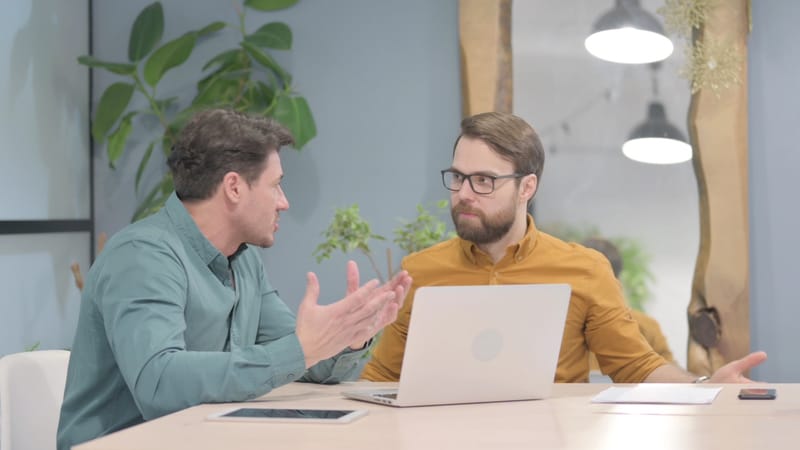 Two men sitting at a desk having a mentoring discussion