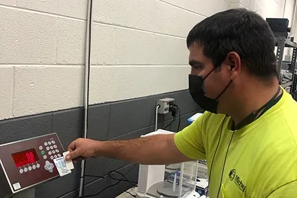 Michelli technician applying a certified scale sticker after inspection