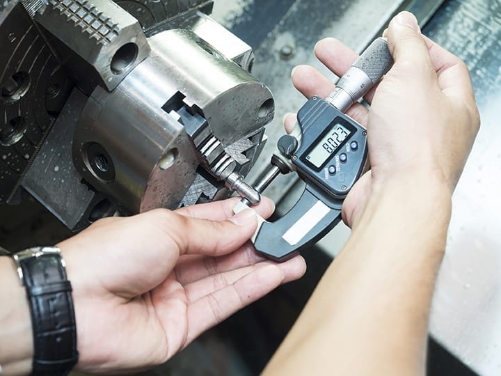 Michelli technician calibrating a micrometer against a certified gauge block reference standard