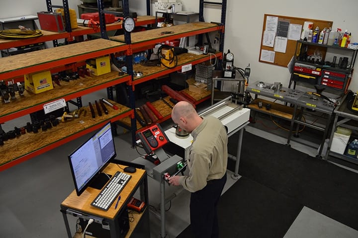 Overhead view of a Michelli torque calibration bench with torque wrenches and calibration standards
