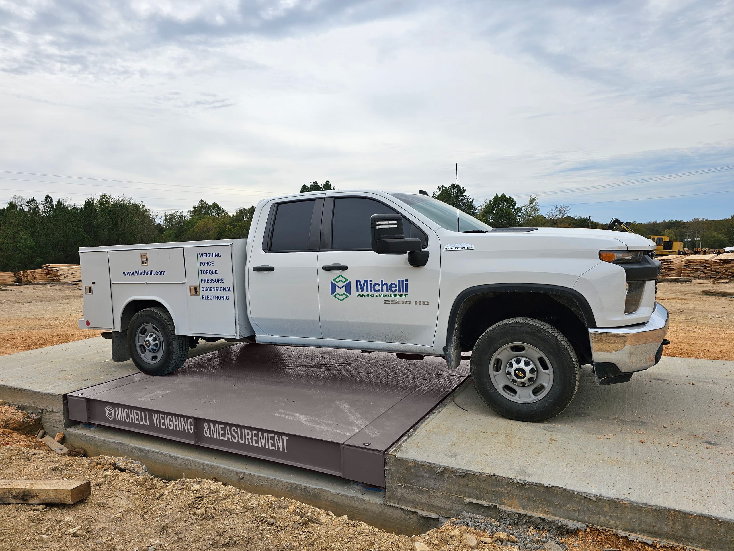 White truck parked on an industrial weighing scale outdoors