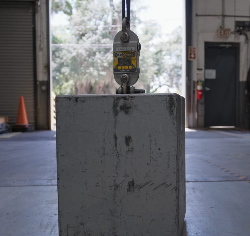 A load cell device measures the weight of a large block inside a warehouse