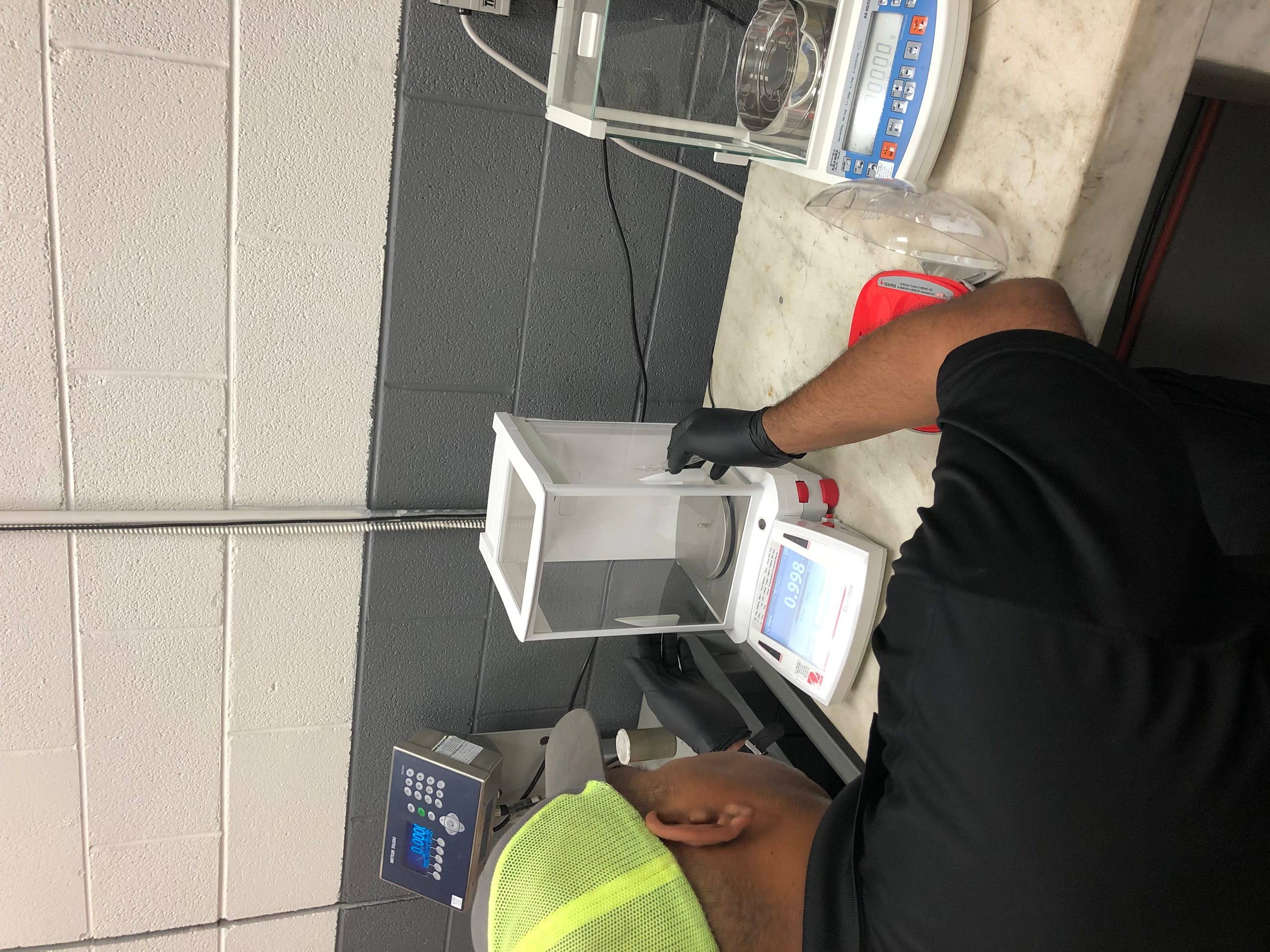 A lab technician using a precision balance scale in a laboratory setting