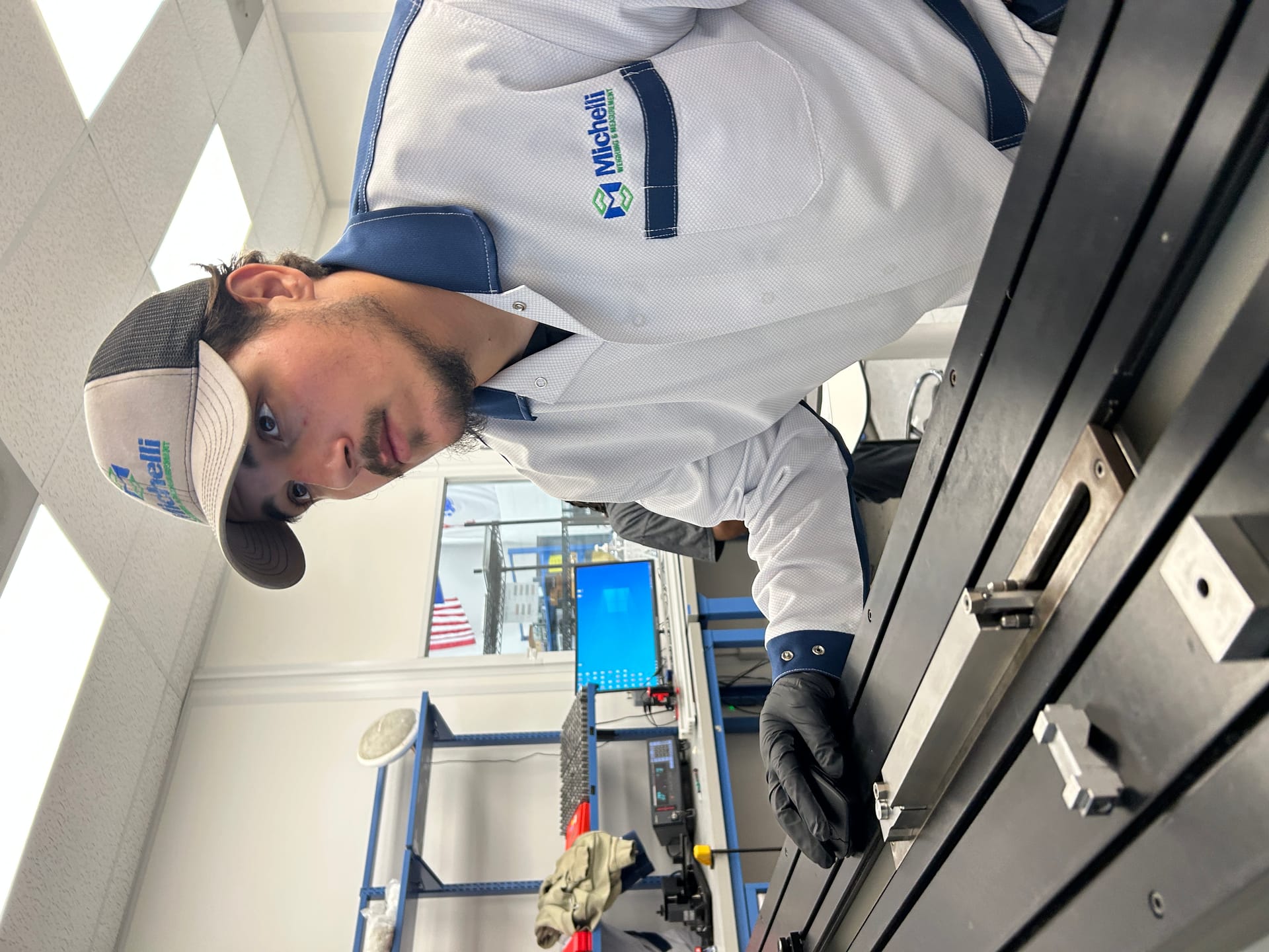 A technician in uniform and cap inspecting machinery on a workbench.