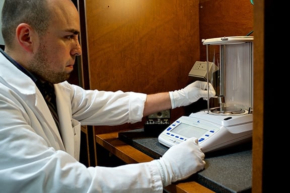 A technician calibrates an analytical balance