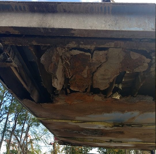 Rot on the left side underneath a truck scale caused by failure to clean debris