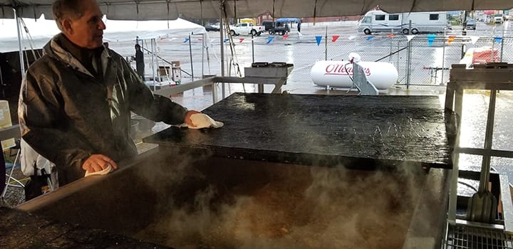Chef John Folse stands over the World's Largest Pot of Gumbo before cooking