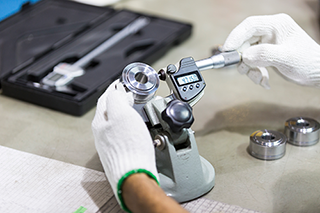 Digital micrometer calibration being performed by a precision measurement technician