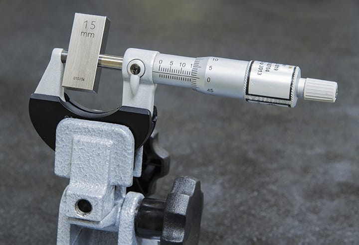 Mechanical micrometer calibration in progress using a precision gage block as reference standard