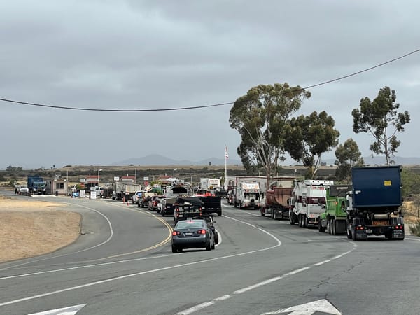 Queue of trucks lined up on an overcast roadway