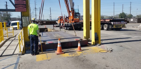 Construction site with oversize load truck and worker at a waste and recycling facility