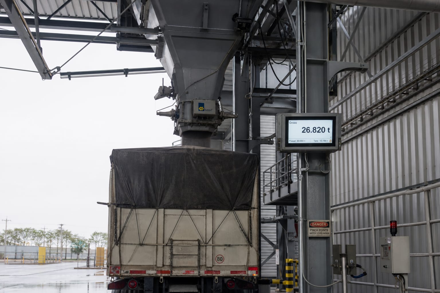 Industrial bulk material shipping and loadout station with weight indicator display