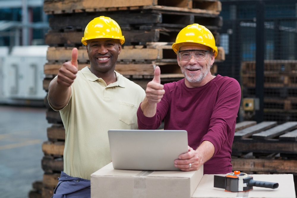 Workers use a laptop & give thumbs up symbol