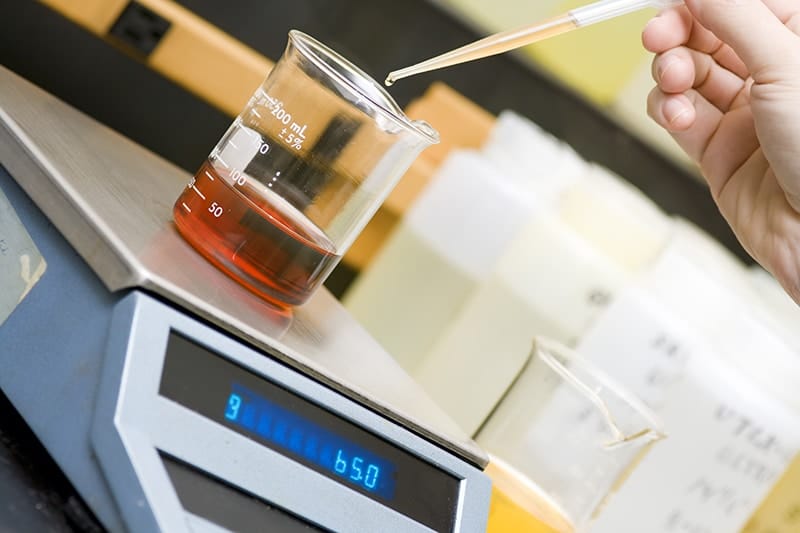 Michelli Weighing & Measurement technician calibrating laboratory balance equipment in a controlled lab environment