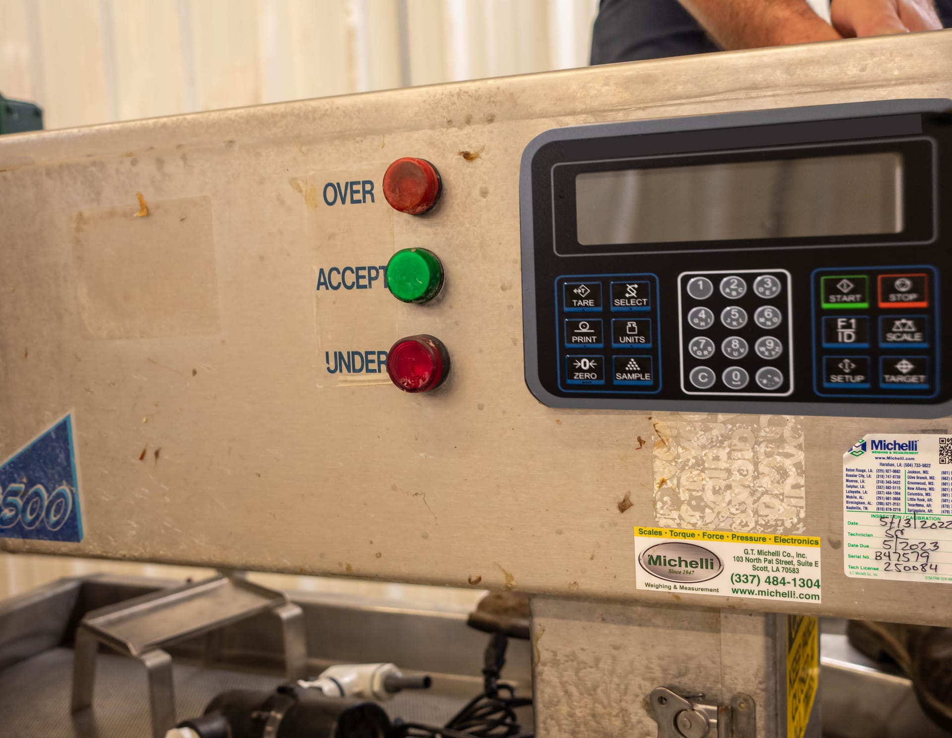 Close-up of an industrial scale control panel with LCD display and Over, Accept, and Under indicator lights