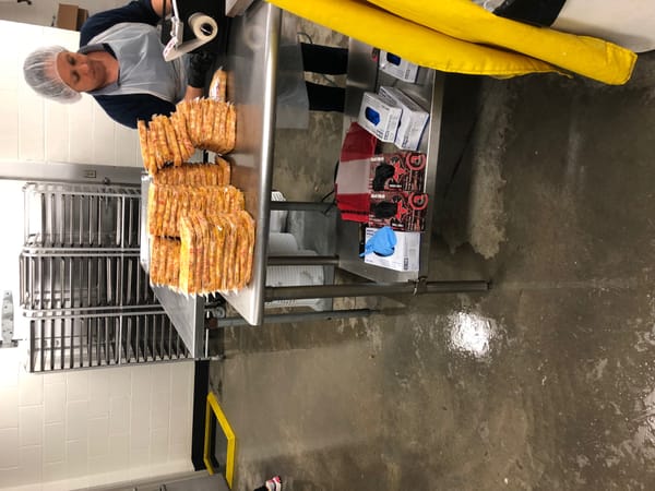 Wrapped food products on a stainless steel table in an industrial packaging facility
