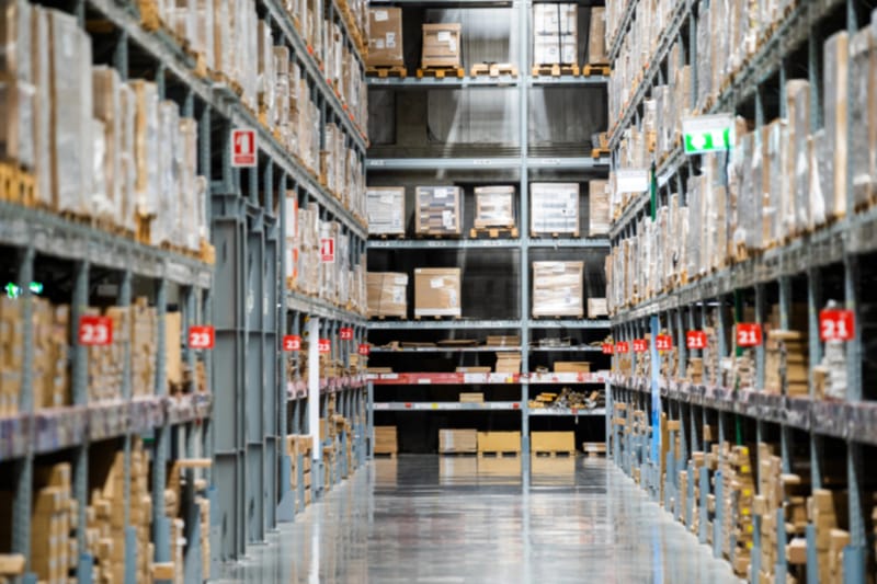 Large warehouse interior with shelves stacked with boxes for inventory counting and management