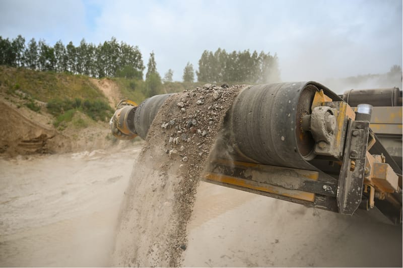 Conveyor belt unloading gravel at a construction site for process monitoring