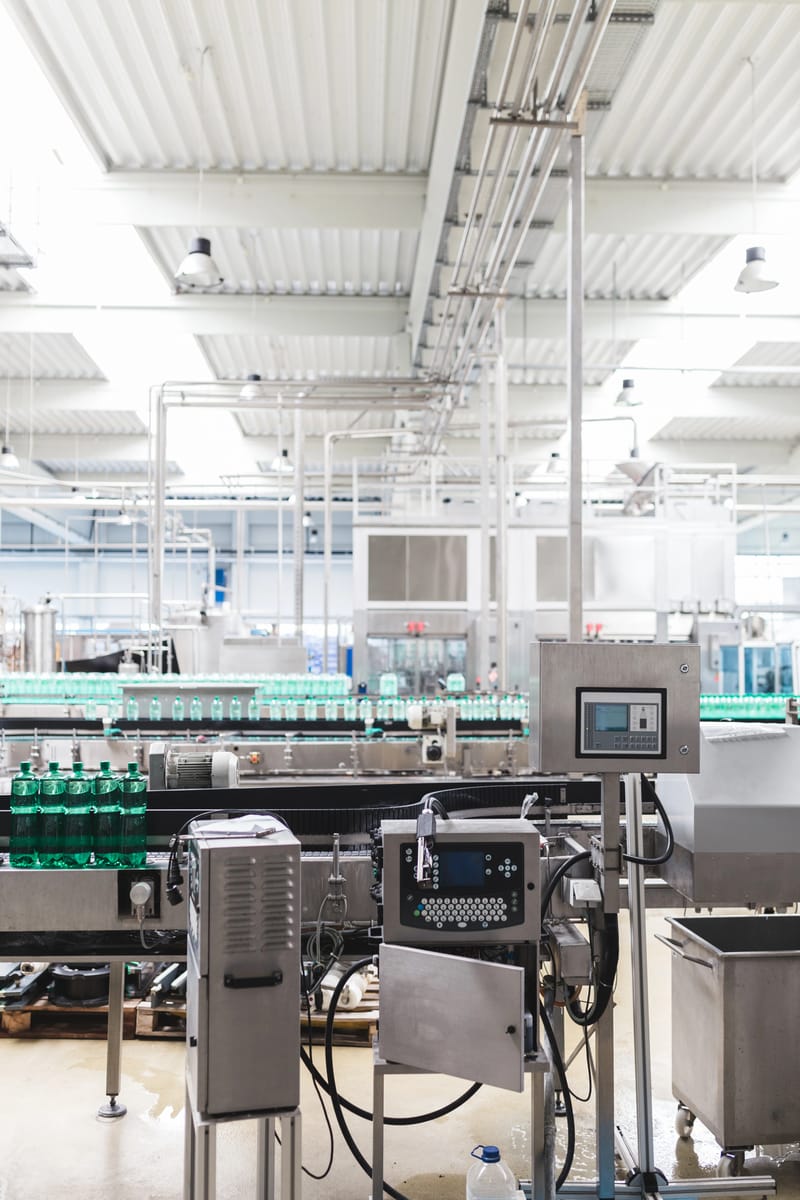 Modern beverage bottling facility automated assembly line representing OEM and partner system components