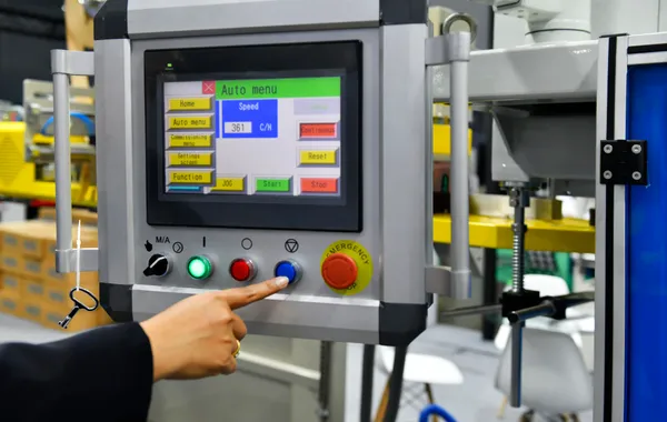 Industrial machine control panel operation representing retrofit and upgrade opportunities for existing automated equipment