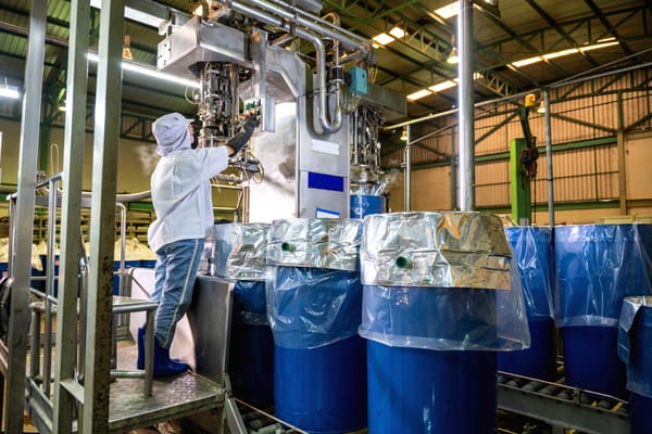 Worker operating machinery in an industrial facility representing liquid, drum, and tote filling applications