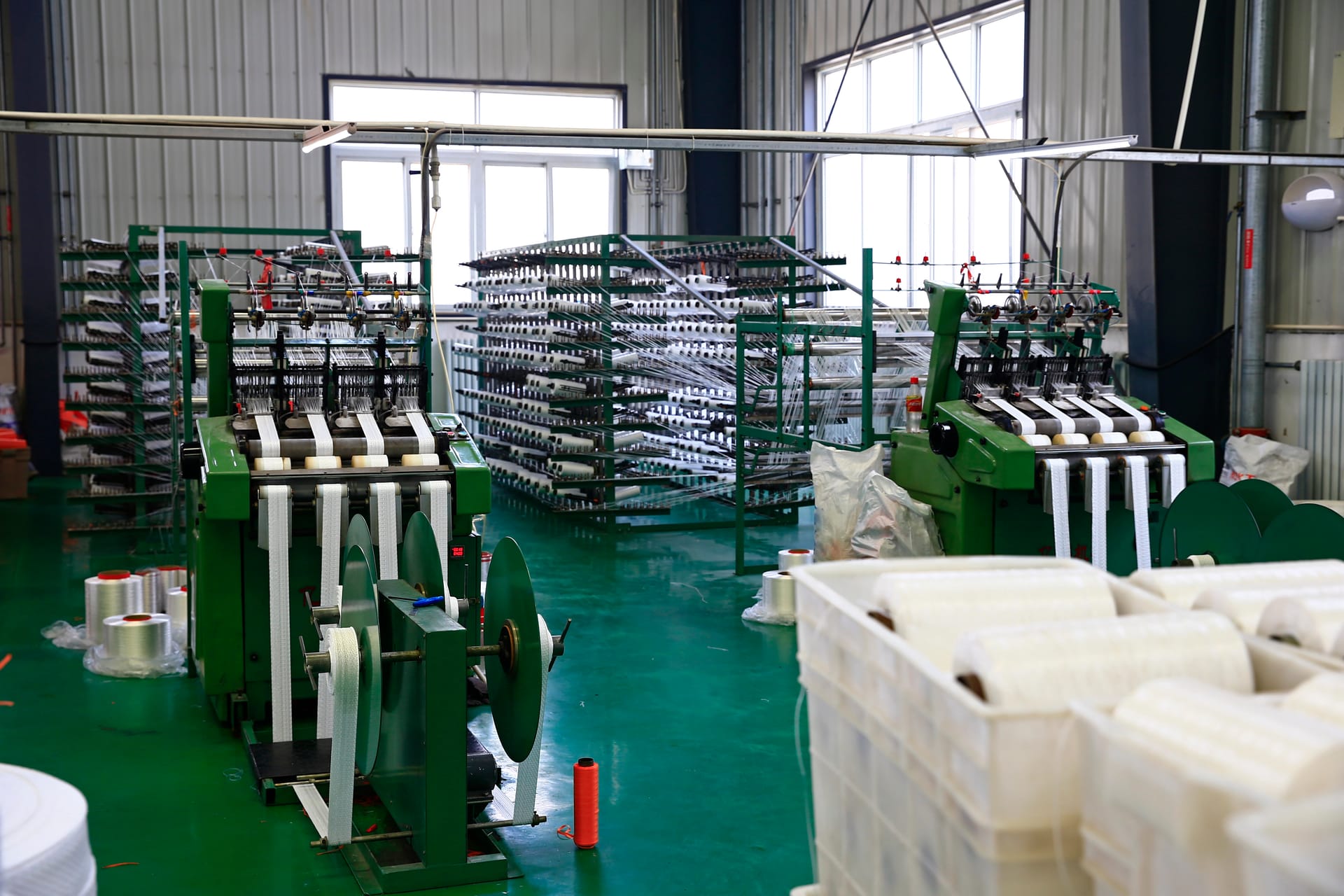 Textile weaving machines in a factory setting representing OEM and partner systems