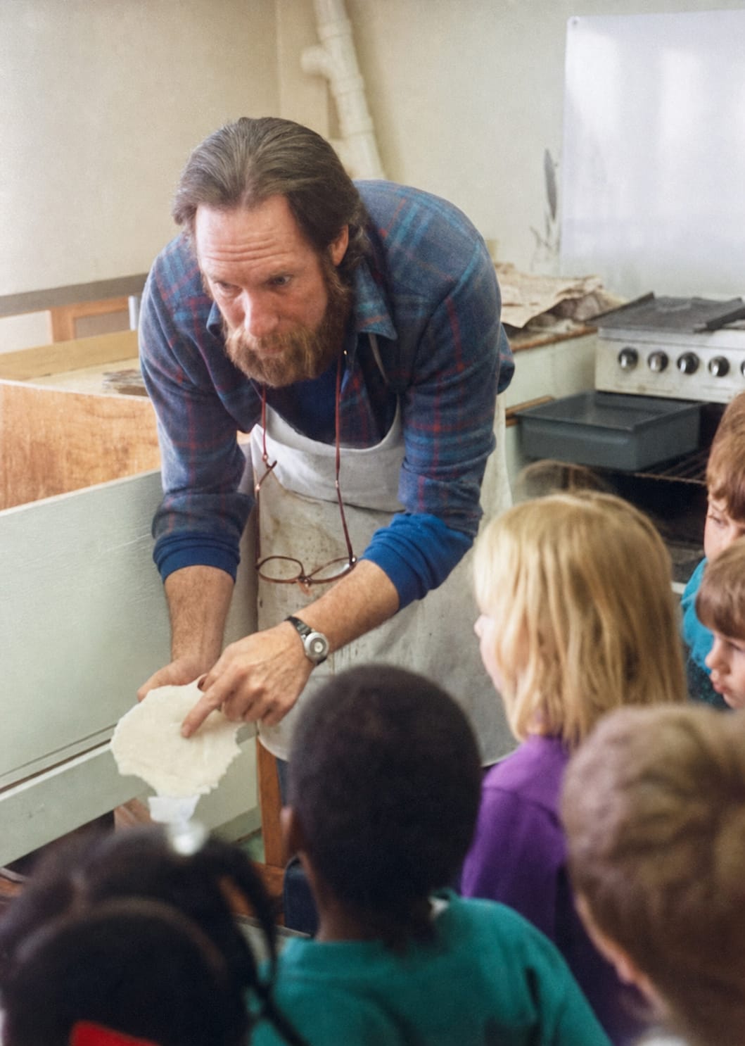 Michael Franco's father demonstrates the original candle-making craft to a group of children inside the Candle Factory workshop.