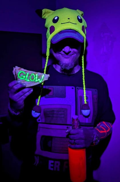 Brando, Founder of Everybody Glows, glowing under black light