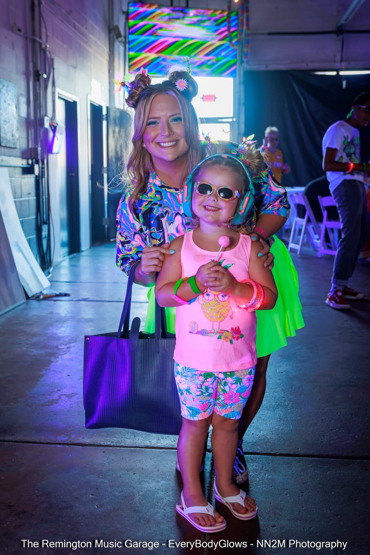 A woman and child dressed in colorful neon outfits with glowing accessories