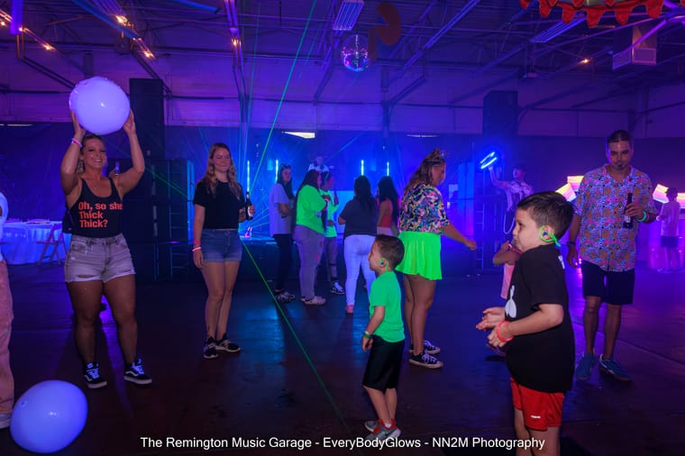 People enjoying a neon-themed dance event with glowing lights and music