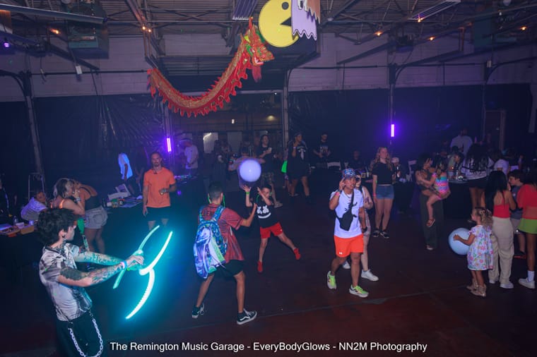 Group of people dancing under neon lights at a music event