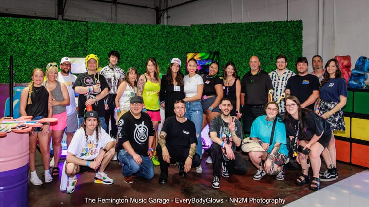 A diverse group of people posing together at an indoor event with vibrant decorations