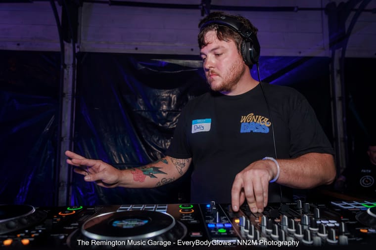 A DJ wearing headphones performs at a music venue