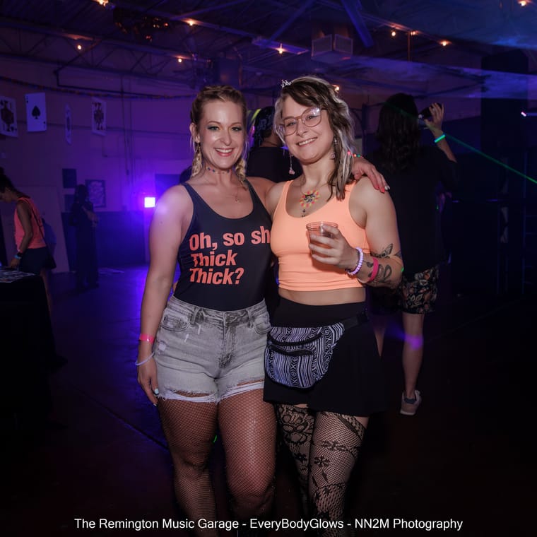 Two women smiling and posing together at a music event