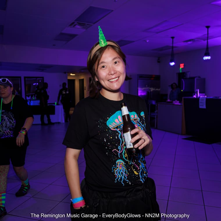 Person at a neon-themed party wearing a headband with a glowing horn