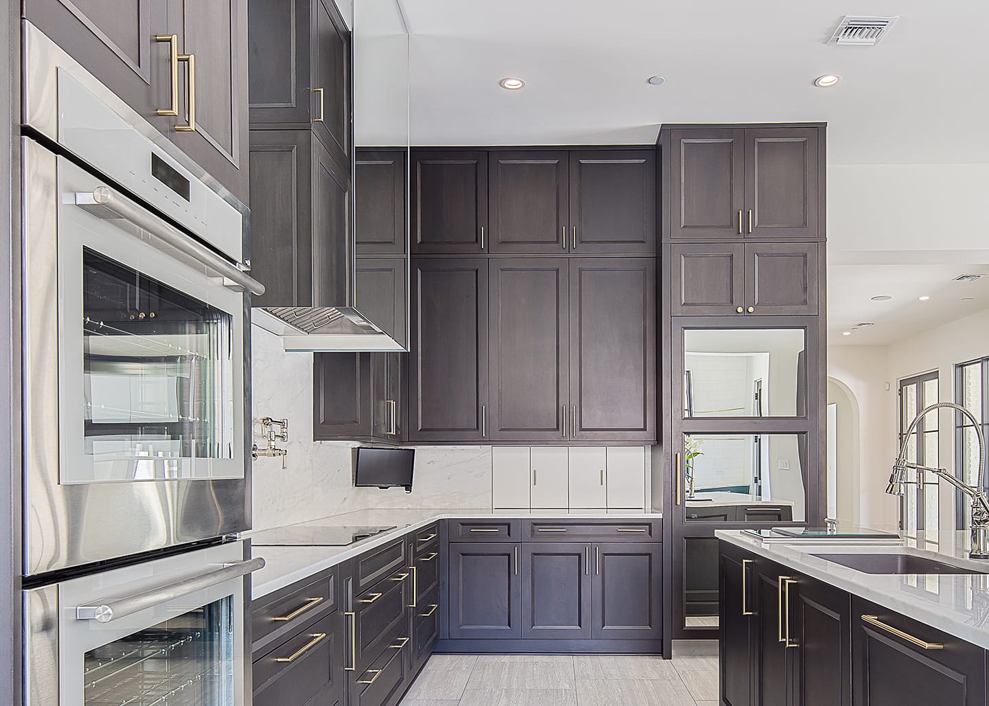 Kitchen hood and Sub-Zero refrigerator with mirror cladding