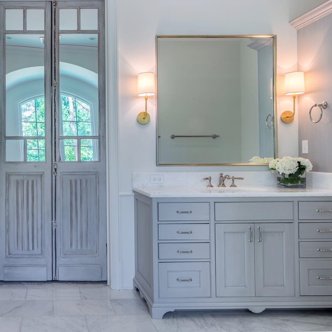Elegant master bathroom with custom vanity by The Cottage