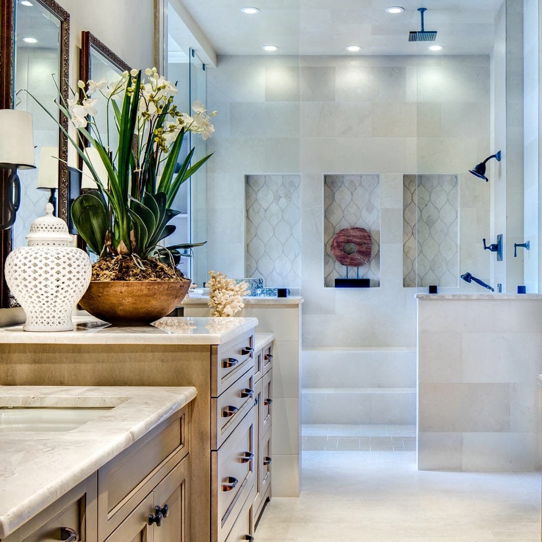 Luxurious bathroom with custom tile and cabinetry by The Cottage Shreveport