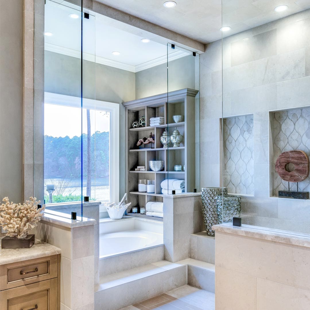 Elegant bathroom with frameless glass shower by The Cottage