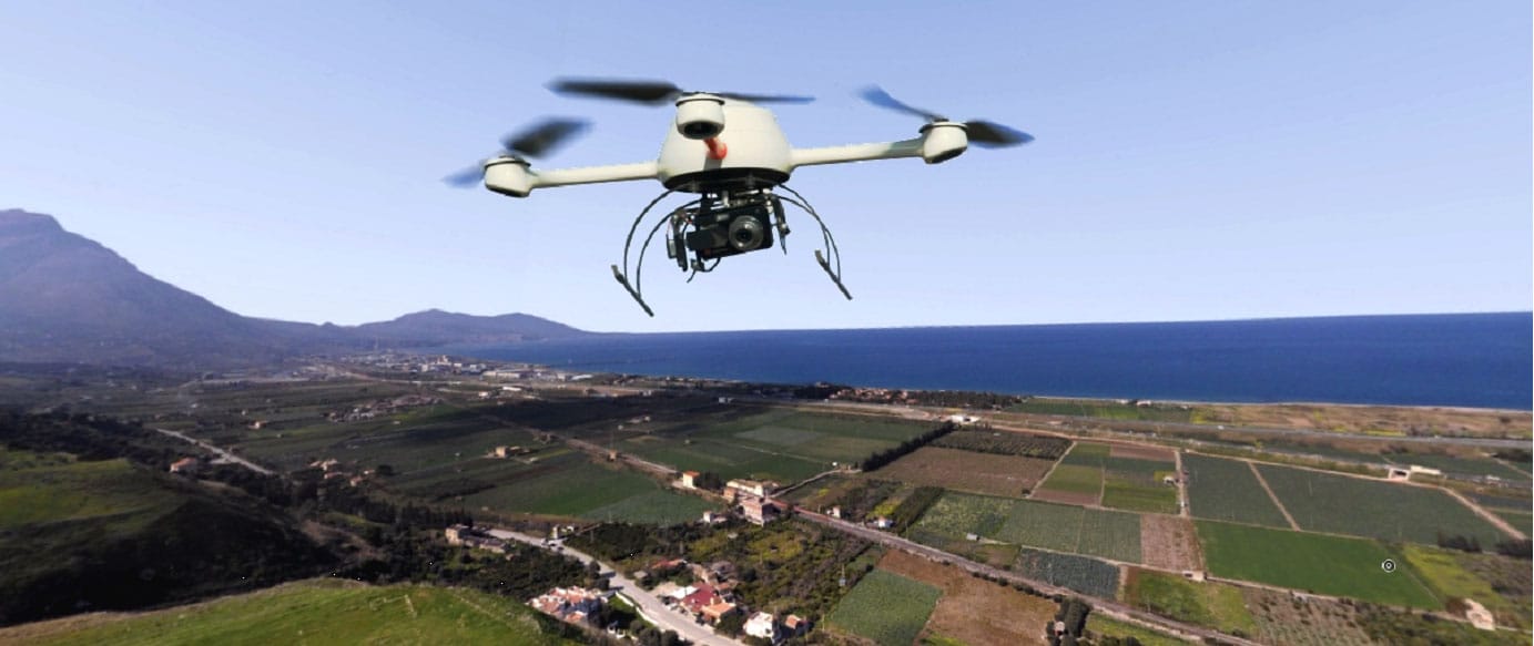 Survey drone with camera flying over farmland